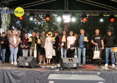 pamiątkowa fotografia wyróżnionych i nagrodzonych podczas X Zlotu Pojazdów Zabytkowych wraz z przedstawicielami organizatorów i przyjaciółmi na scenie w Parku HDK w Działdowie